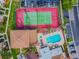 Aerial view featuring tennis court and a pool with lounge chairs in a well-maintained community at 1967 Cormorant Ct # 515, Clearwater, FL 33762
