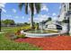 Community entrance with a decorative fountain, lush landscaping, and community sign at 1967 Cormorant Ct # 515, Clearwater, FL 33762