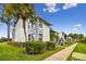 Inviting condo building featuring well-maintained landscaping, and a clear blue sky at 1967 Cormorant Ct # 515, Clearwater, FL 33762