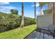 A cozy backyard with privacy hedges, palm trees and a cement patio and exterior chair at 2007 Searay Shore Dr, Clearwater, FL 33763
