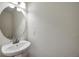 A pedestal sink and round mirror in a half bathroom providing functionality and style at 2007 Searay Shore Dr, Clearwater, FL 33763