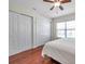 Bright bedroom featuring hardwood floors, two closets, a ceiling fan, and natural light from the window at 2007 Searay Shore Dr, Clearwater, FL 33763