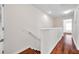 Hallway with wood floors features a half wall with painted trim, a door, and recessed lighting at 2007 Searay Shore Dr, Clearwater, FL 33763