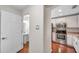 Hallway view to half bath, kitchen with stainless appliances, and wood flooring at 2007 Searay Shore Dr, Clearwater, FL 33763