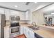 Bright kitchen featuring stainless appliances, white cabinetry, and a breakfast bar overlooking the dining area at 2007 Searay Shore Dr, Clearwater, FL 33763