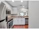 The kitchen features stainless appliances, white cabinets, a sink, and hardwood flooring at 2007 Searay Shore Dr, Clearwater, FL 33763