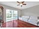 Cozy living room showcasing hardwood floors, large window, and stylish white leather sofa at 2007 Searay Shore Dr, Clearwater, FL 33763
