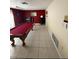 Spacious game room with a red billiard table, tile flooring and natural light at 2043 Sugarbush Dr, Holiday, FL 34690