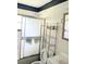 Bathroom with shower, toilet, metal storage shelf, and mirror at 2414 S 67Th St, Tampa, FL 33619