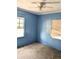Bedroom featuring blue walls, carpeted floors, natural light, and a ceiling fan at 2414 S 67Th St, Tampa, FL 33619