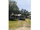 Exterior shot of a quaint one story home with mature trees and driveway at 2414 S 67Th St, Tampa, FL 33619