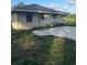 The home's backyard showcases a concrete patio area bordered by untamed greenery, with the back facade of the home in view at 2518 Mabry St, Tampa, FL 33618