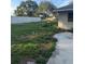 An exterior view featuring the home's front yard and partially obscured facade, showing the lawn and partial fence at 2518 Mabry St, Tampa, FL 33618