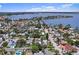 Expansive aerial view of the property surrounded by mature trees near a scenic lake at 257 43Rd Ave, St Pete Beach, FL 33706