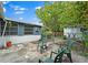 Backyard area featuring a stone patio, mature trees, a storage shed, and chain link fence at 257 43Rd Ave, St Pete Beach, FL 33706