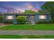 Charming single-story home boasts a well-maintained lawn, blue chair, and vibrant landscaping for lovely curb appeal at 257 43Rd Ave, St Pete Beach, FL 33706