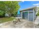 Back patio with a stone table and blue umbrella, offering a cozy outdoor dining and relaxation space at 257 43Rd Ave, St Pete Beach, FL 33706