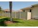 A vinyl fence surrounds the yard of this house, with green grass and a nearby palm tree at 2784 Alexander Dr, Clearwater, FL 33763