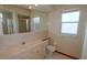 Bathroom featuring a toilet and sink with cabinets, a mirror, and tile walls at 2784 Alexander Dr, Clearwater, FL 33763