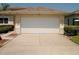 View of the two-car garage with a white door and trimmed landscaping on both sides at 2784 Alexander Dr, Clearwater, FL 33763