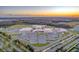 Aerial view showcasing the expansive campus and parking area, all set against a vibrant sunset backdrop at 3236 Barbour Trl, Odessa, FL 33556