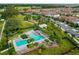 An aerial view of a modern community pool, surrounded by palm trees, lounge areas, and neighborhood amenities at 3236 Barbour Trl, Odessa, FL 33556