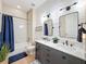 A modern bathroom with shiplap walls, dual vanity sinks, and a shower-tub combination with stylish fixtures at 3236 Barbour Trl, Odessa, FL 33556