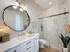Modern bathroom featuring a glass enclosed shower, decorative mirror, and stylish fixtures at 3236 Barbour Trl, Odessa, FL 33556