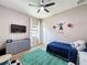 Cozy bedroom with a ceiling fan, a mounted TV, a themed rug, and natural light from the window at 3236 Barbour Trl, Odessa, FL 33556