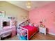 A room with unique light fixture, bright bedding, and playful decor at 3236 Barbour Trl, Odessa, FL 33556