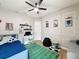 A stylish bedroom with a themed rug, ceiling fan, computer desk, and decor at 3236 Barbour Trl, Odessa, FL 33556