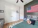 Charming bedroom featuring a hardwood floor, ceiling fan, and a decorative American flag accent wall at 3236 Barbour Trl, Odessa, FL 33556