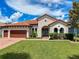 Charming home with a red tile roof, lush green lawn, and manicured landscaping creates inviting curb appeal at 3236 Barbour Trl, Odessa, FL 33556