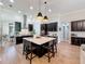 Stylish kitchen features a large island, pendant lighting, dark cabinetry, and stainless steel appliances at 3236 Barbour Trl, Odessa, FL 33556