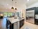 Open kitchen with stainless steel appliances and large island, flowing into the living room at 3236 Barbour Trl, Odessa, FL 33556