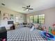 Bright living area with large windows, ceiling fan, and playful decor, perfect for Gathering entertainment at 3236 Barbour Trl, Odessa, FL 33556