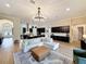 Living room and kitchen with a large white sectional sofa, modern lighting, and hardwood floors at 3236 Barbour Trl, Odessa, FL 33556