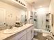 Bathroom featuring double sinks, a glass-enclosed shower, and ample cabinet space for storage at 32977 Kaloko Rd, Wesley Chapel, FL 33543
