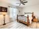 Charming bedroom with a ceiling fan, soft lighting, and wood-look floors, exuding warmth at 32977 Kaloko Rd, Wesley Chapel, FL 33543