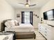 Cozy bedroom with a ceiling fan, TV, and neutral decor, creating a restful retreat at 32977 Kaloko Rd, Wesley Chapel, FL 33543