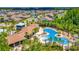 Aerial view of luxurious multi-section community pool with cabana and dining areas, surrounded by lush landscaping at 32977 Kaloko Rd, Wesley Chapel, FL 33543