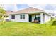 Spacious backyard with green grass, an outdoor seating area, an AC unit, and a covered patio at 33668 Elm Hill Branch, Wesley Chapel, FL 33545