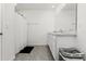 White bathroom featuring a double granite vanity, large mirror, shower with white curtain, and tile flooring at 33668 Elm Hill Branch, Wesley Chapel, FL 33545