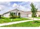 Charming single-story home with a well-kept lawn, showcasing a modern exterior with a symmetrical design at 33668 Elm Hill Branch, Wesley Chapel, FL 33545