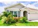 Charming single-story home with a well-manicured lawn and beautiful landscaping at 33668 Elm Hill Branch, Wesley Chapel, FL 33545