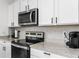 Updated kitchen with stainless steel appliances, granite countertops, and white cabinetry at 33668 Elm Hill Branch, Wesley Chapel, FL 33545