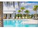 Sparkling pool area with ample lounge seating and a stylish building with white siding at 33668 Elm Hill Branch, Wesley Chapel, FL 33545