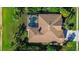 Aerial view of home showing roof and backyard, with a pool in the screened enclosure at 3895 Mimosa Pl, Palm Harbor, FL 34685