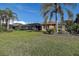 Expansive backyard with mature trees, a screened-in patio, and lush green lawn, great for outdoor enjoyment at 3895 Mimosa Pl, Palm Harbor, FL 34685