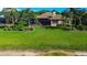 Expansive backyard with lush green lawn, mature trees, and a screened-in patio, perfect for outdoor living at 3895 Mimosa Pl, Palm Harbor, FL 34685